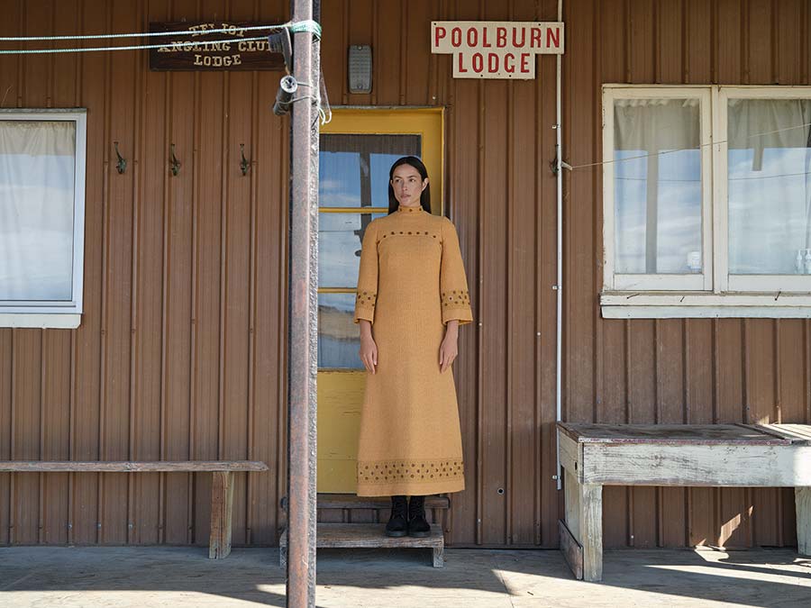 Beverley Horne two-piece hostess gown, 1971. Handspun and hand- woven Perendale wool, gold thread, sequins and copper beads, EH13. Photographed at Poolburn Lodge, 2024. Model: Ngahuia Williams. Image supplied by Te Papa Press/Eden Hore Central Otago. Image © Derek Henderson. WORD CHCH 2025 03