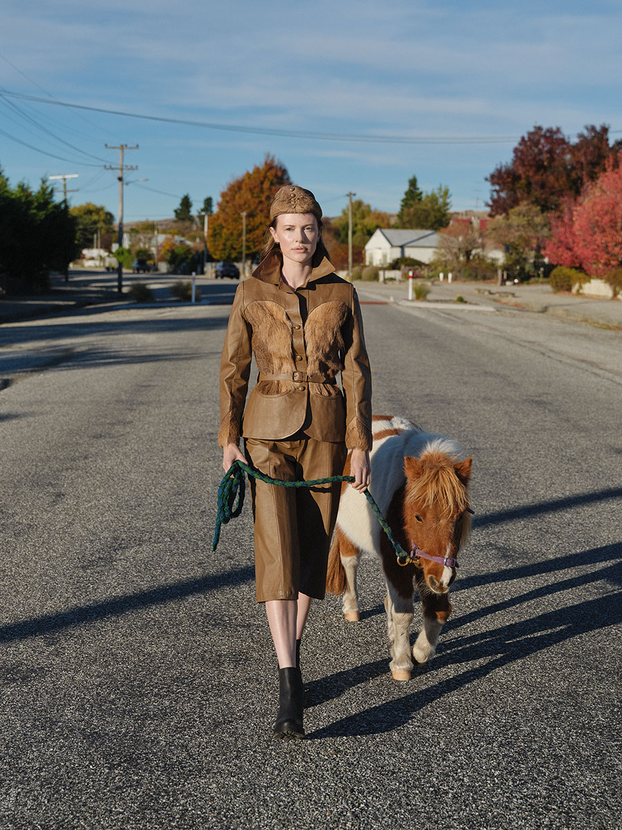 Jo Dunlap jacket, gauchos, camisole and cap, 1979. Leather and deer hide, EH213. Photographed at Ophir with Pippi the miniature horse, 2024. Model: Alannah Kwant. Image supplied by Te Papa Press/Eden Hore Central Otago. Image © Derek Henderson. WORD CHCH 2025 05